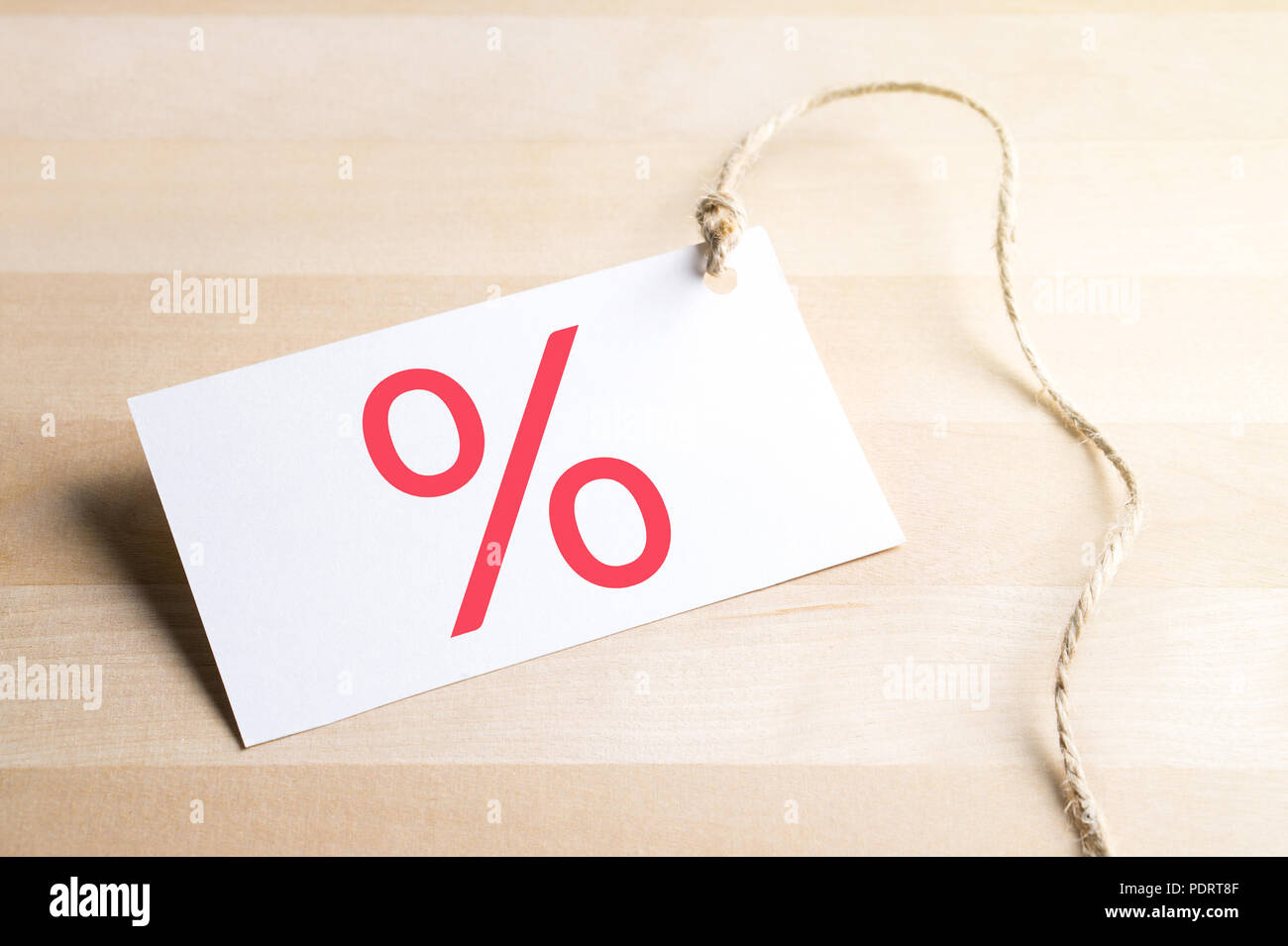 Bargain prices, sale and special offer concept. Price tag with percent symbol on wooden table. Stock Photo