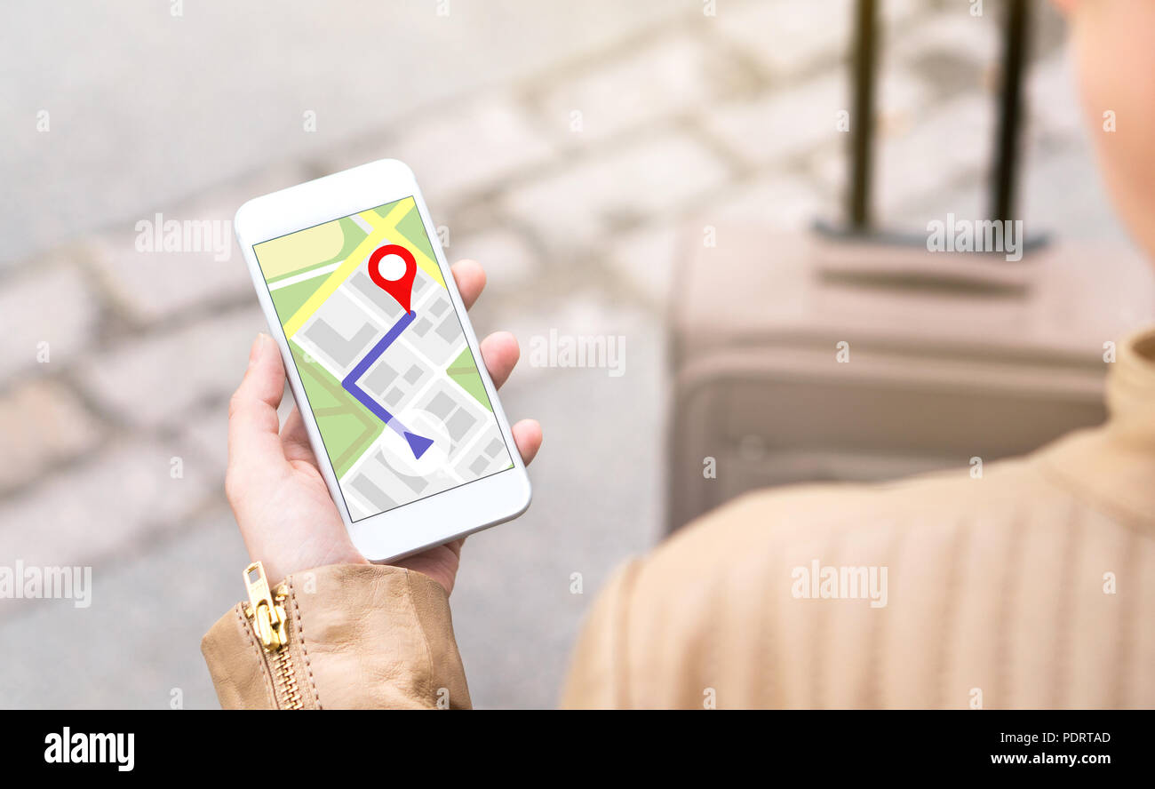 Woman navigating with mobile phone map application. Tourist with walking route on smartphone screen. Traveler with baggage using GPS. Stock Photo