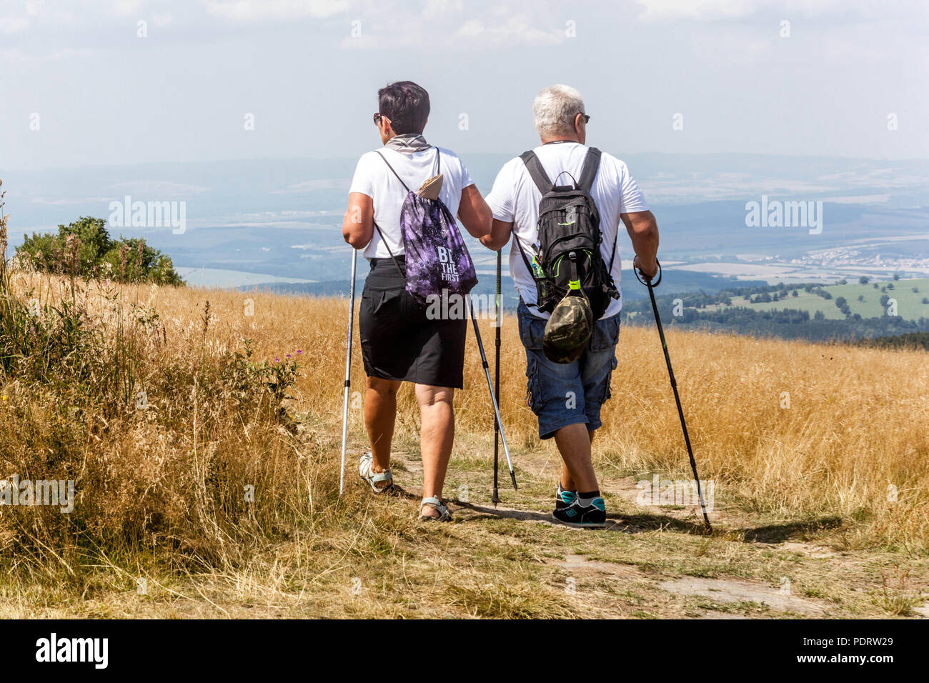 Senior couple Nordic walking outdoors People couple walking mountain trail healthy lifestyle walking poles couple Senior couple walking active older Stock Photo