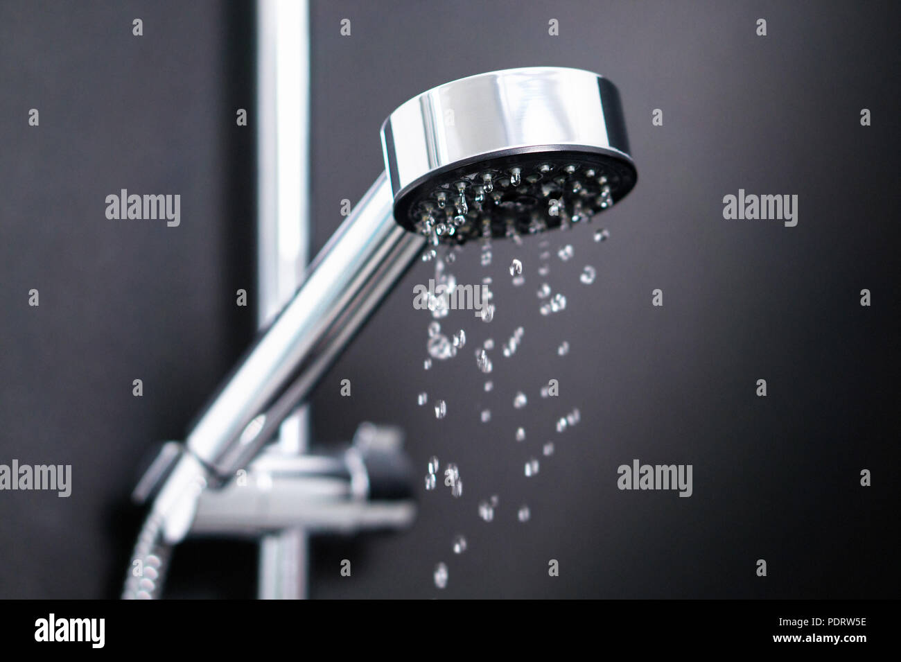Turning off or on running water in shower. Last or first drops splash from faucet. Water consumption, bill, saving, shortage and ecology concept. Stock Photo