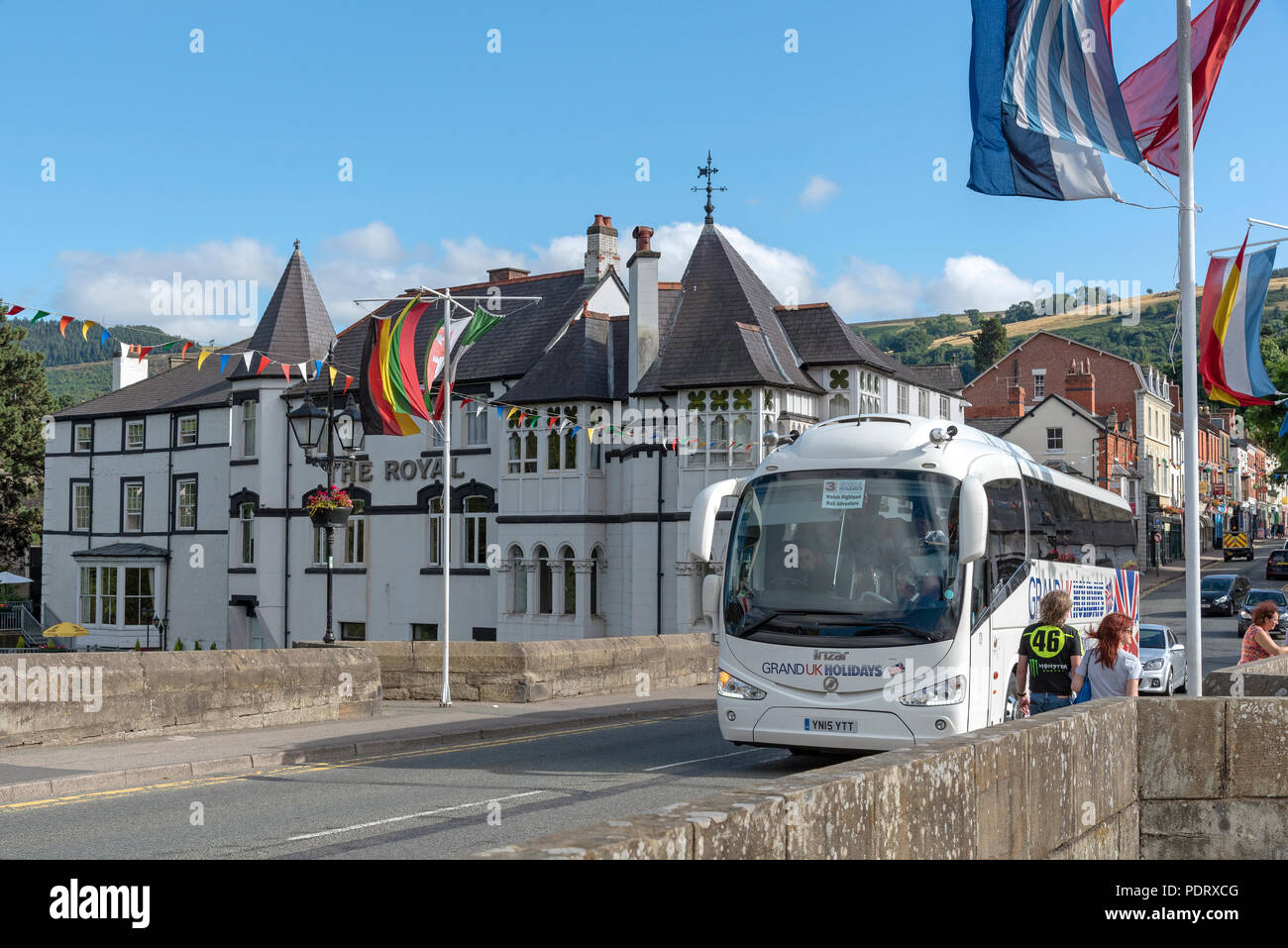 Llangollen, Denbighshire, North Wales, UK. A popular tourist attraction which stands on the River Dee. A tourbus passing over the town bridge. Stock Photo