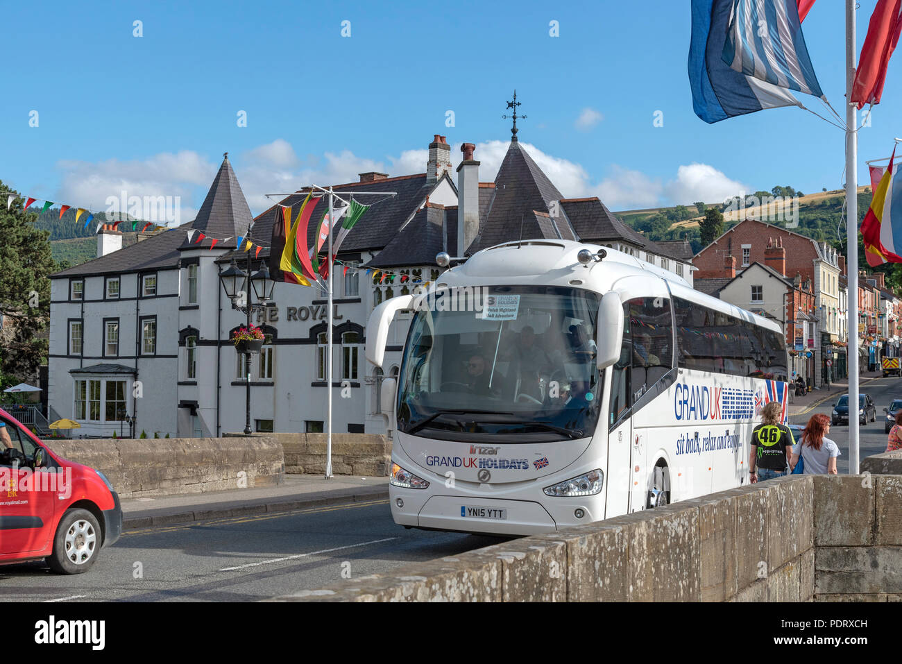 Llangollen, Denbighshire, North Wales, UK. A popular tourist attraction which stands on the River Dee. A tourbus passing over the town bridge. Stock Photo