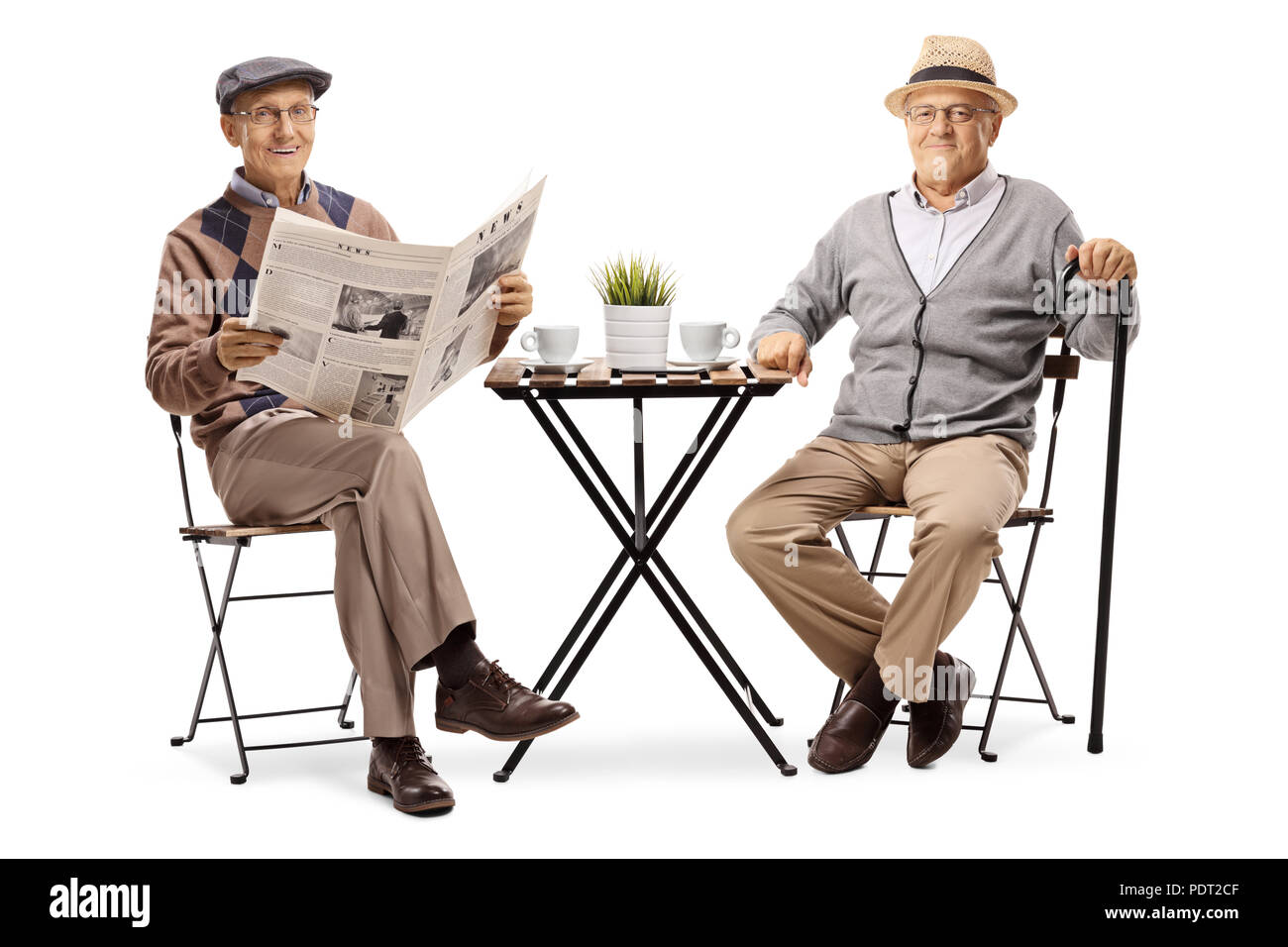 Two elderly men sitting at a coffee table and looking at the camera