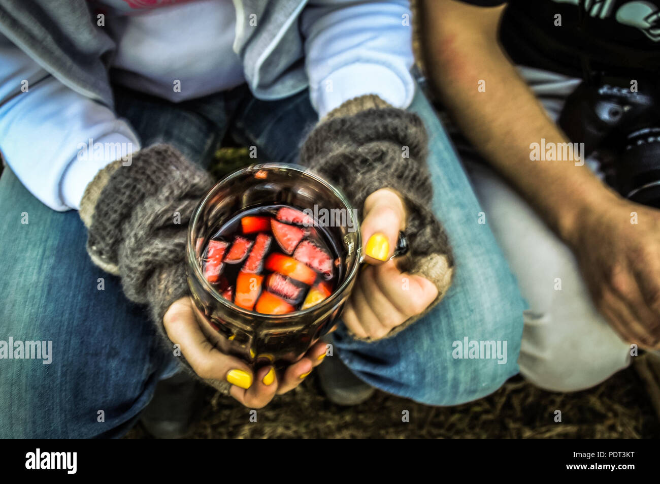 Top drunk view of the girl's hands holding a big glass mug with hot mulled wine. World through the eyes of a drunk concept Stock Photo