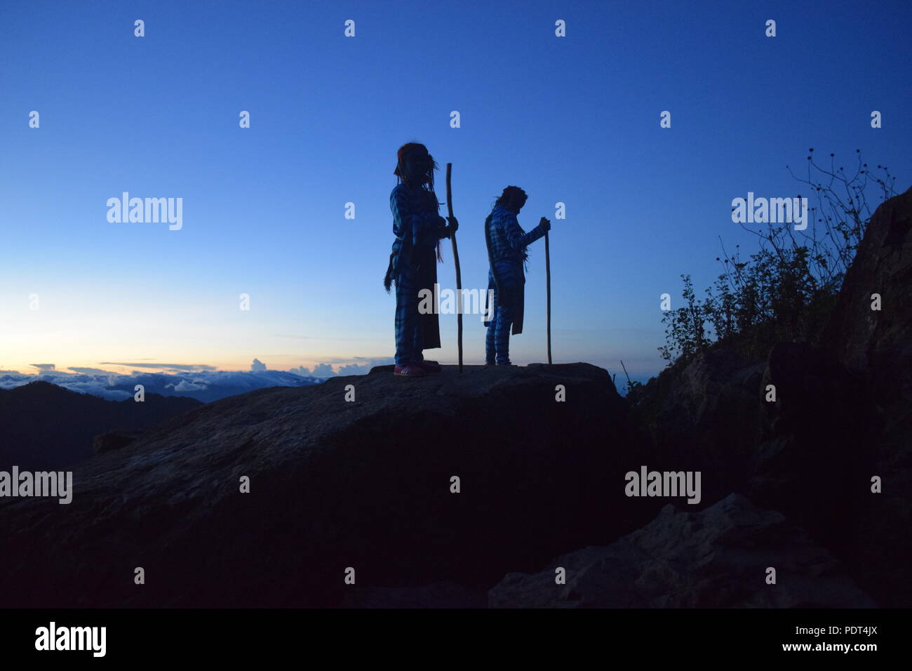 Silhouette Timeline of 2 young girls at the morning dusk standing on top of the Ampucao Sta. Fe ridges awaiting the Sunrise at Mount Ulap in Itogon, Stock Photo
