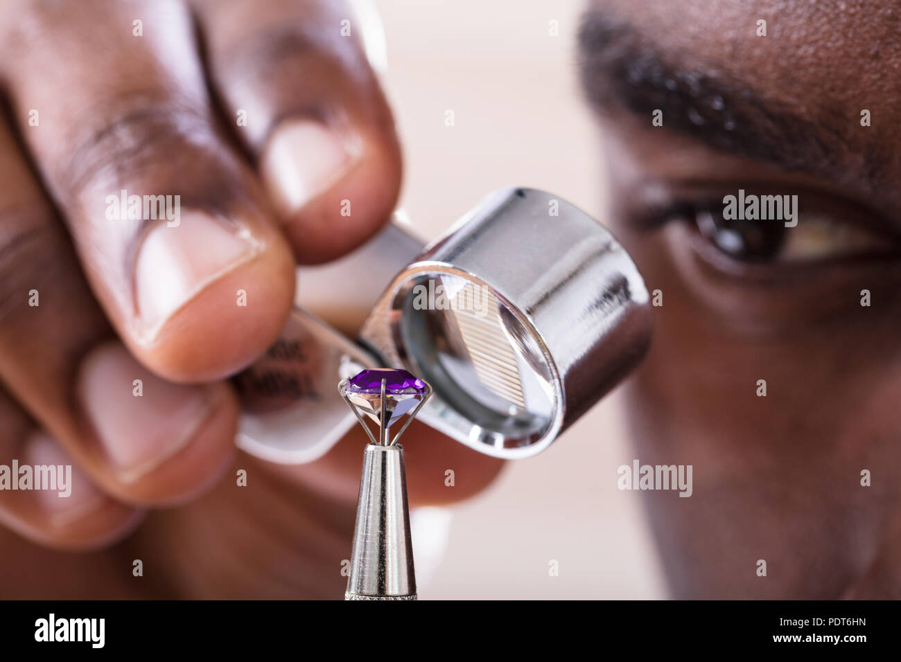 Close-up Of Jeweler Examining Diamond Through Loupe Stock Photo