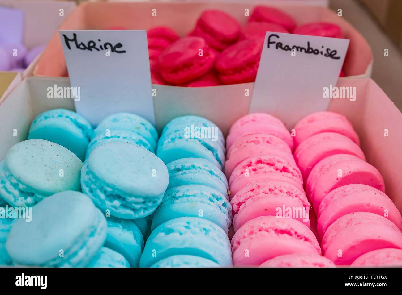 Colorful macarons in boxes for sale at a market stall in Southern France in Nice Stock Photo