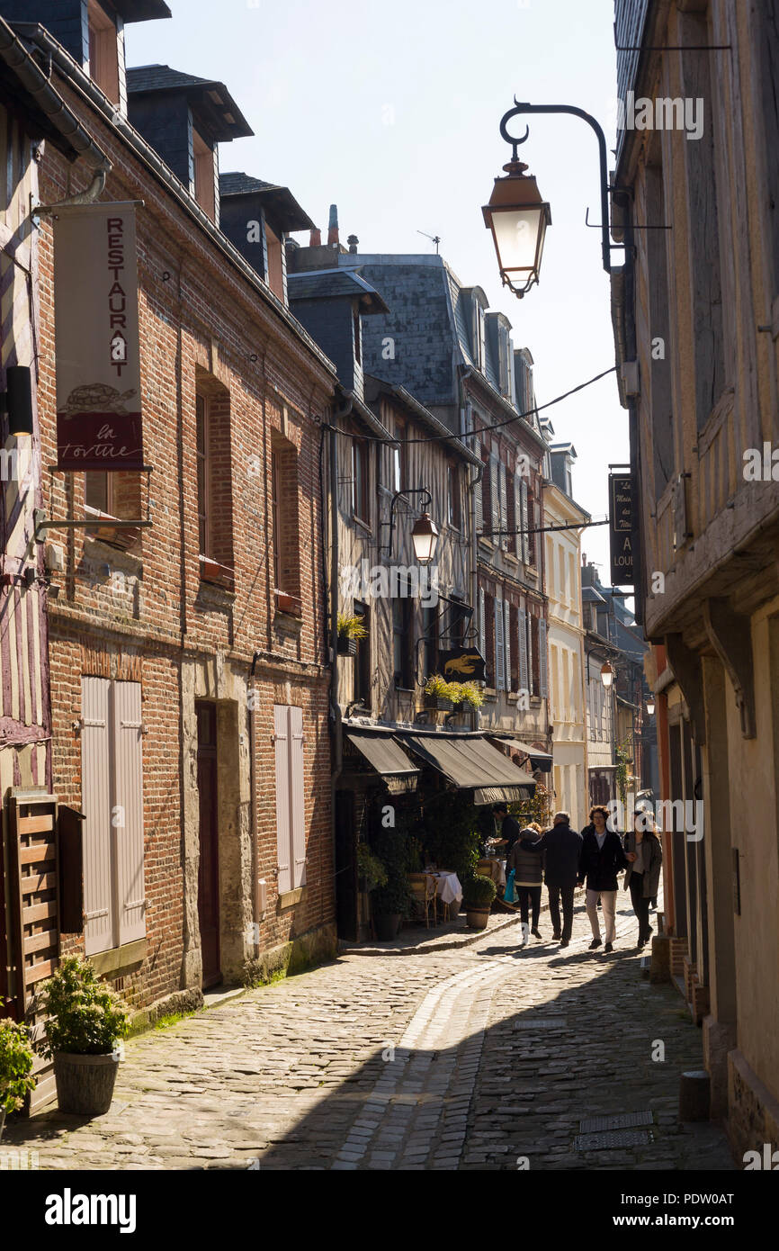 The ancient cobbled street of Rue de L'Homme de Bois with old street lamp in Honfleur, Normandy, France Stock Photo