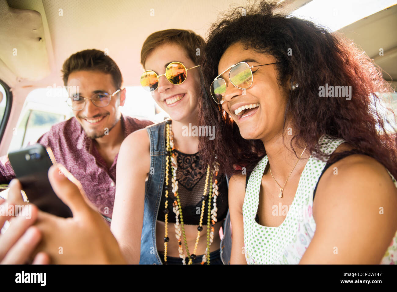 Mixed group of happy young people in a vintage van having fun  Stock Photo