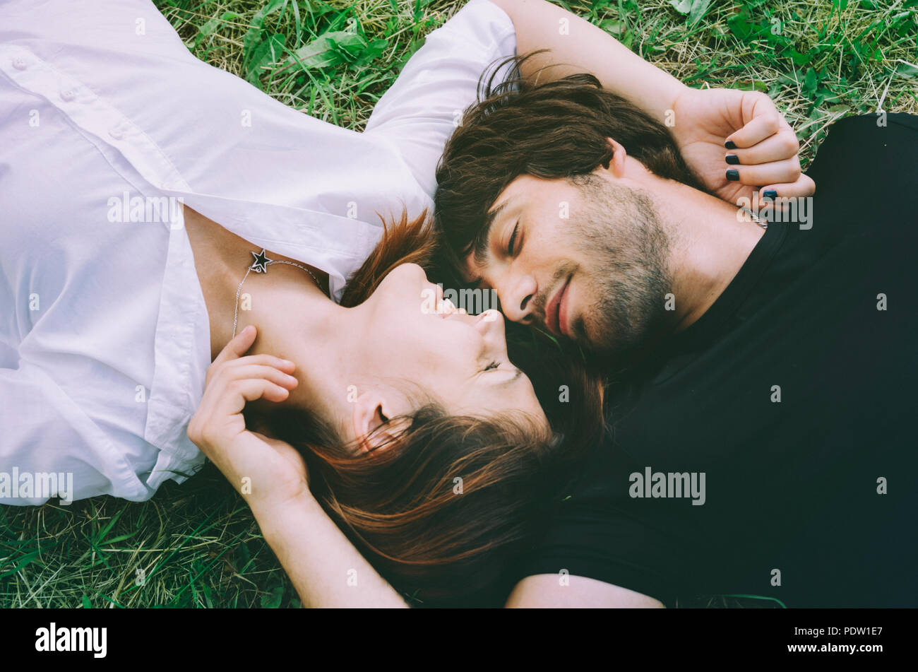 Happy couple lying in the grass Stock Photo - Alamy
