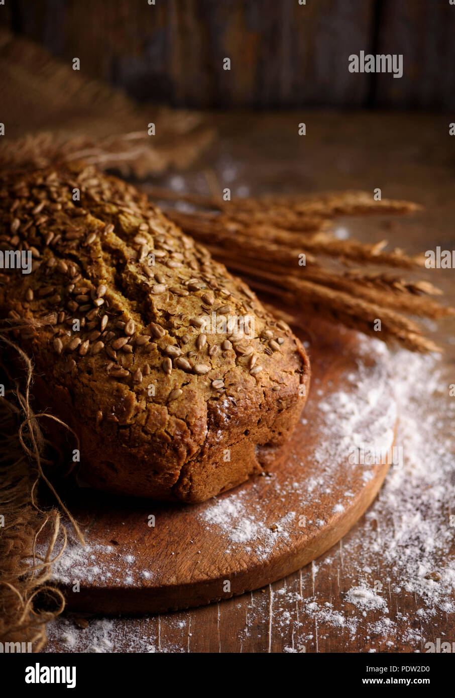 Homemade bread loaf and wheat ears on rustic wooden background Stock ...