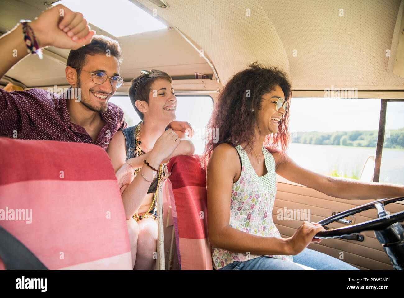 Mixed group of young people going on holiday in a vintage van Stock Photo