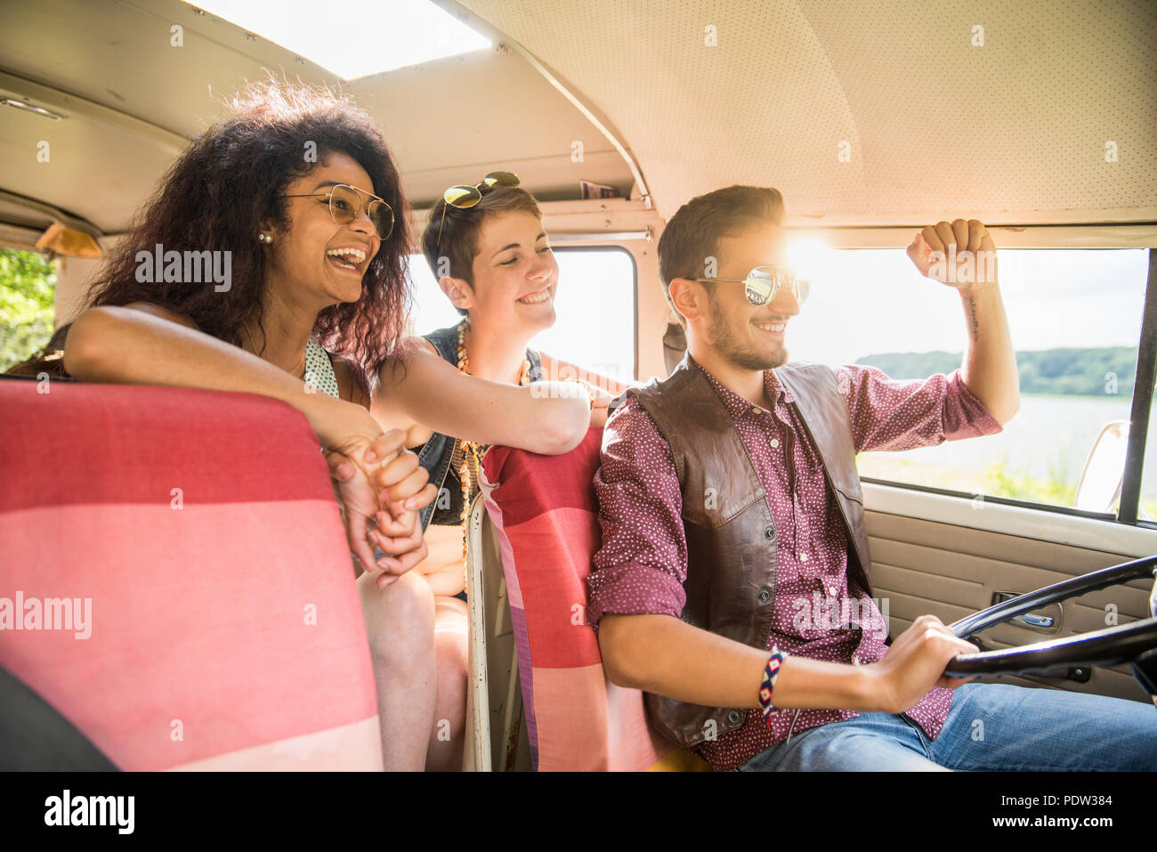 Mixed group of young people going on holiday in a camper van Stock Photo