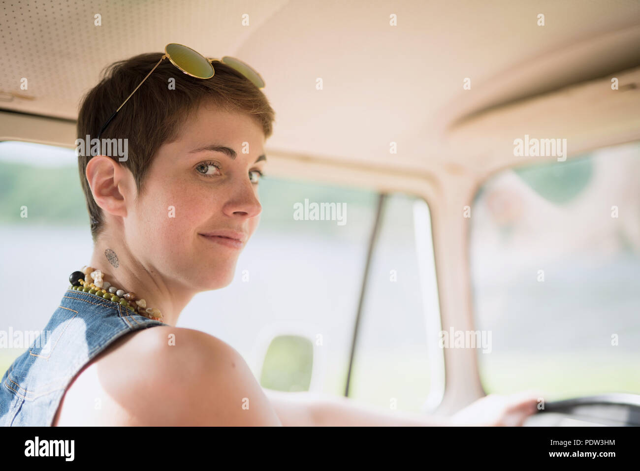 Portrait of a young hipster female goes on holiday with her van Stock Photo