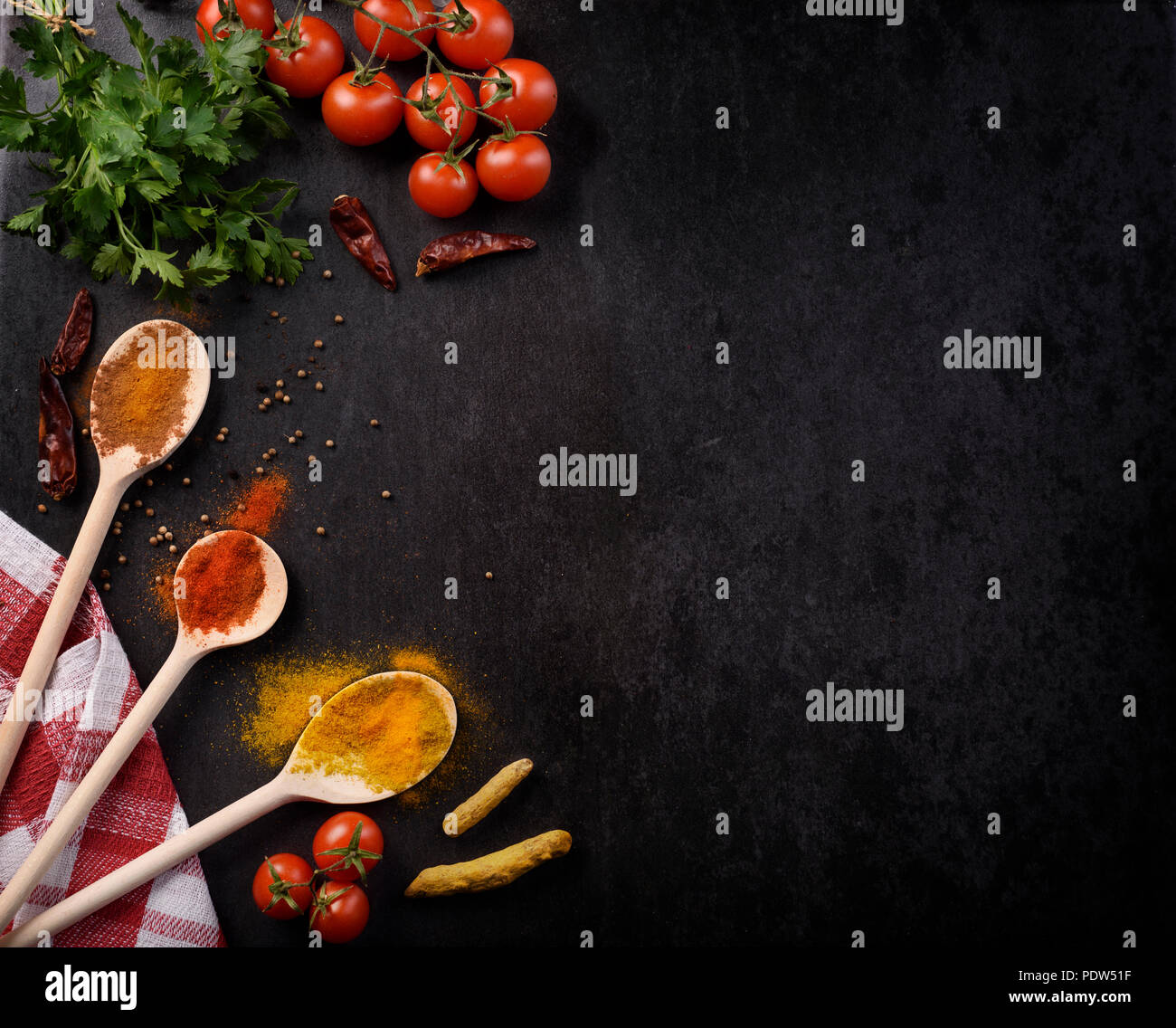 Various spices on rustic black background with copyspace. Stock Photo