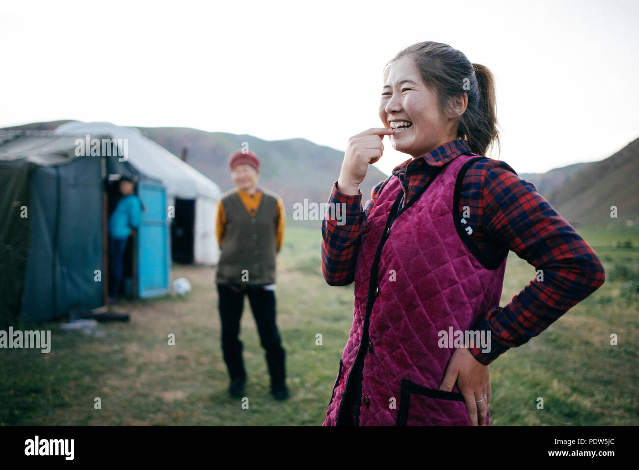 Young Kyrgyz woman smiling in front of her tent in Kyrgazstan Stock Photo