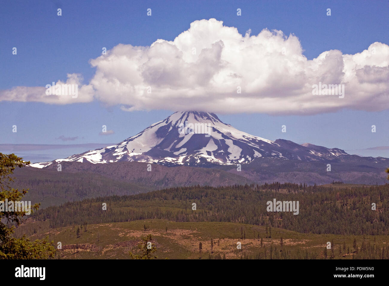 A large cumulus cloud sits atop Mount Jefferson, Oregon's second highest peak, like a hat. Jefferson is a dormant volcano in the Cascade Range of cent Stock Photo