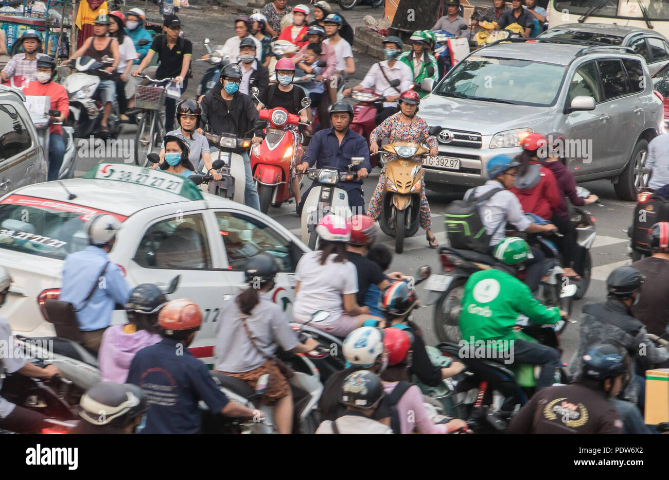 SAIGON, VIETNAM, DEC 14 2017, Dense traffic at intersection with passing through motorbikes and vehicles. Stock Photo