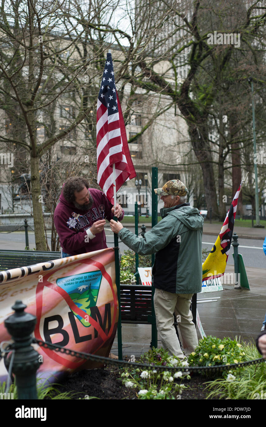Protesters of the second trial of the occupation of the Malheur Wildlife Refuge attaching an American flag to one of their signs. Stock Photo