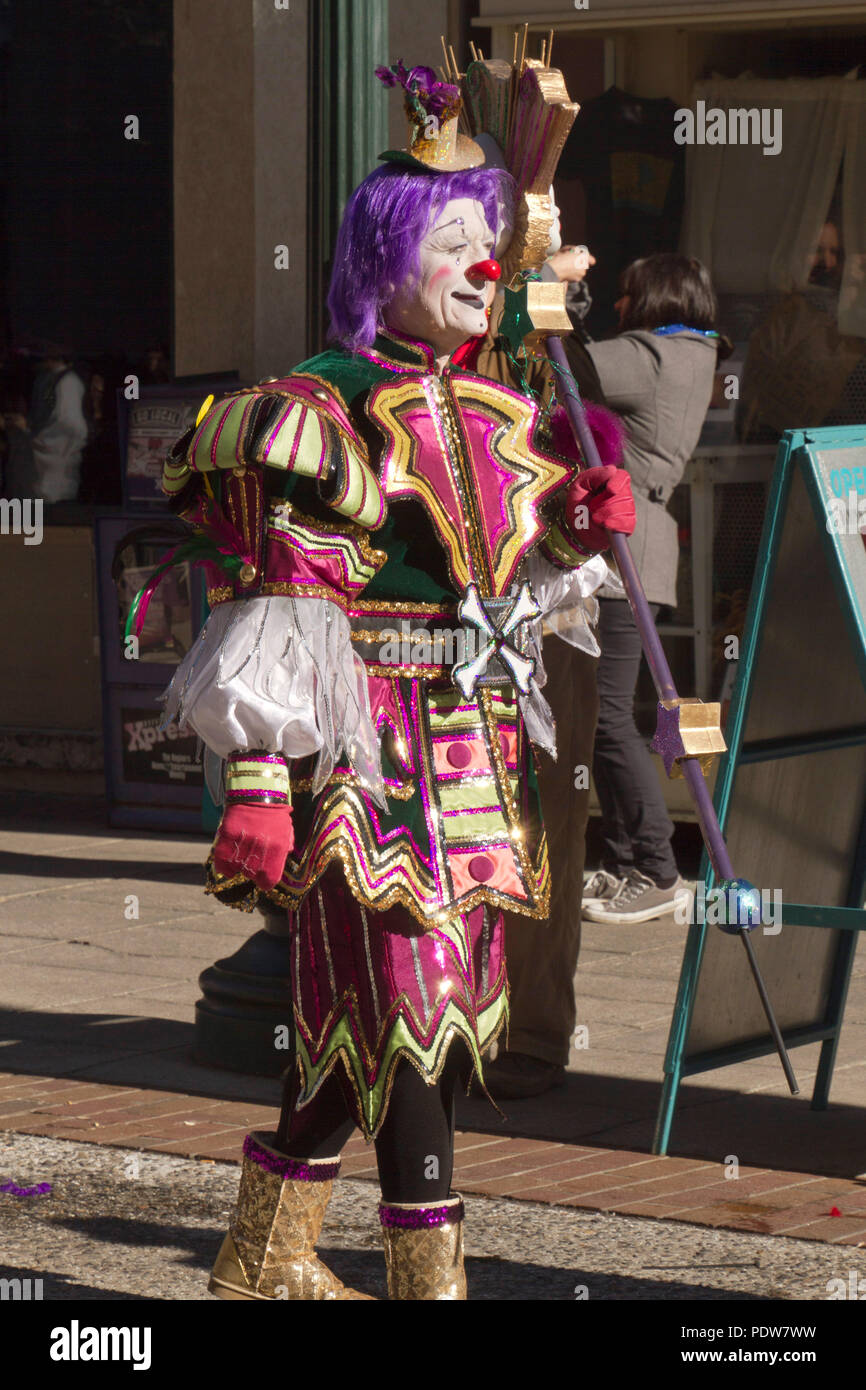 ASHEVILLE, NORTH CAROLINA, USA - FEBRUARY 7, 2016: Colorful and creatively costumed Mardi Gras clown carries a septor in the 2016 Mardi Gras Parade in Stock Photo