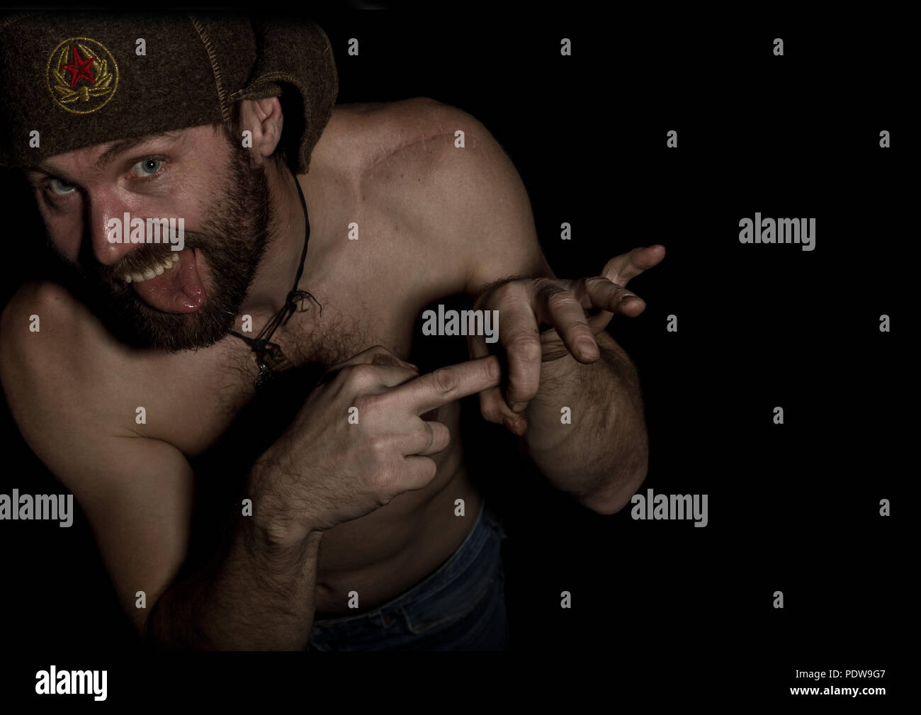 frightening bearded man showing middle finger. strange Russian man with a  naked torso and a woolen hat. free space for your text Stock Photo - Alamy