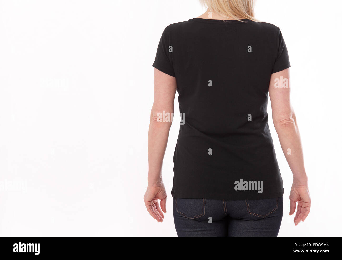 T-shirt design and people concept - close up of woman in blank black shirt, shirt rear isolated. Mock up. Stock Photo