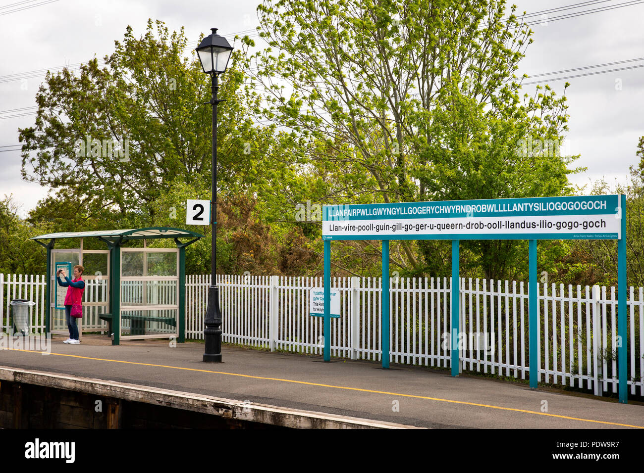 UK, Wales, Anglesey, Llanfairpwllgwyngyllgogerychwyrndrobwllllantysiliogogogoch station name sign with English pronunciaton guide Stock Photo