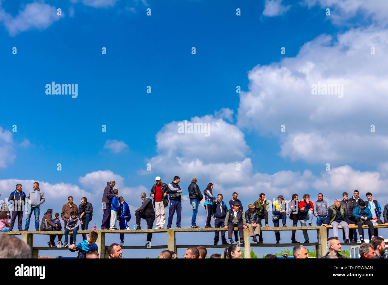 Chestereg, Vojvodina, Serbia - April 30, 2017: Group of people, mostly men is gathered on public happening. Fans are standing on grandstand for better Stock Photo