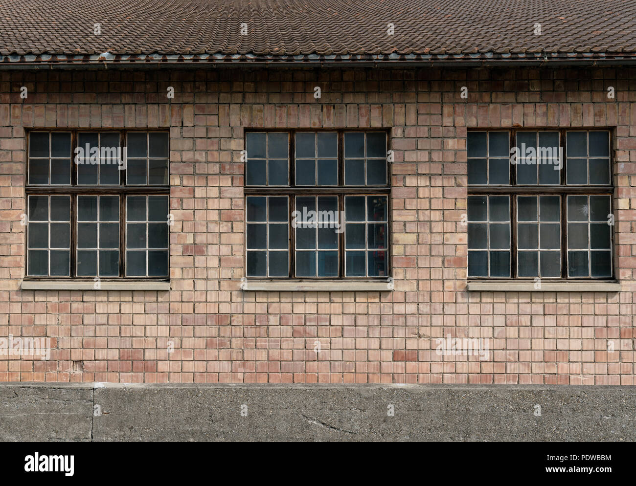 red brick industrial building with large windows Stock Photo - Alamy