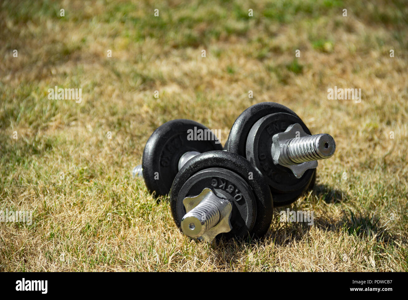 Dumbbells lay on the ground outdoors Stock Photo