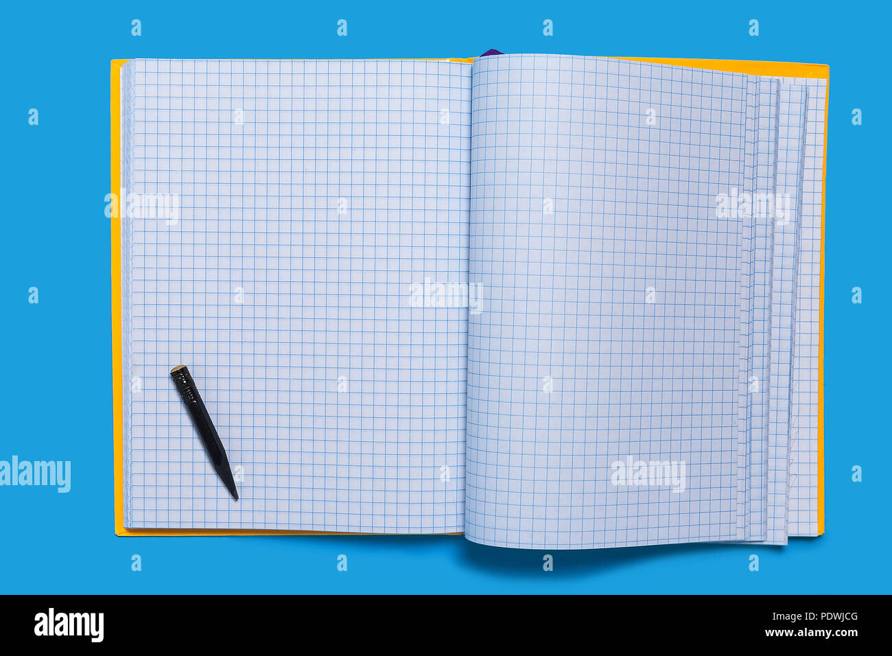 Black used pencil lying on a copybook Stock Photo
