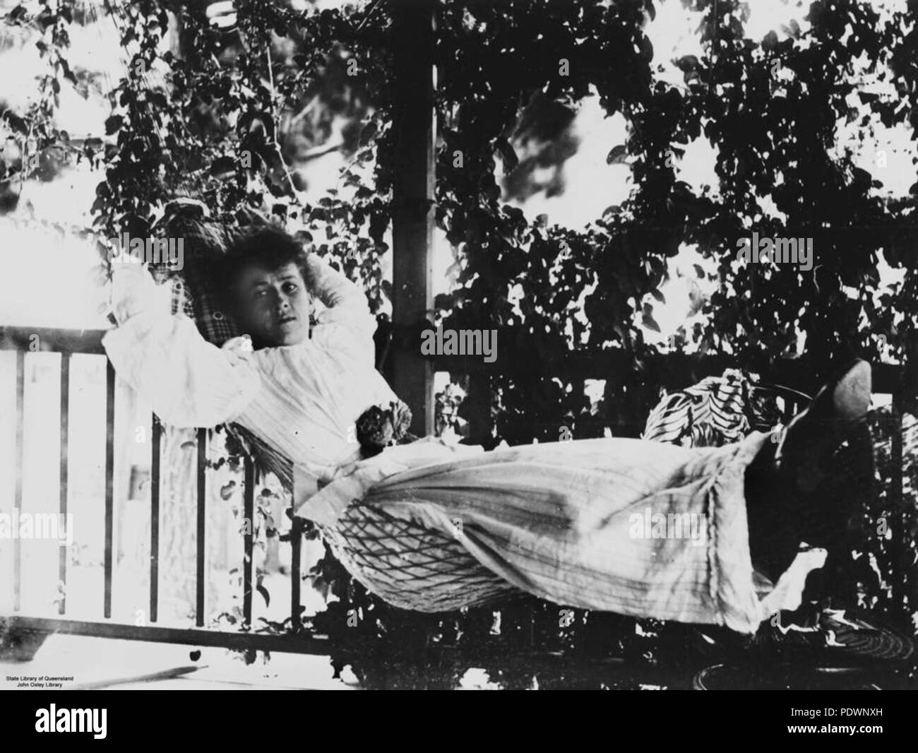 273 StateLibQld 1 78503 Woman in a hammock on the verandah, Fraser Island, Queensland, ca. 1895 Stock Photo