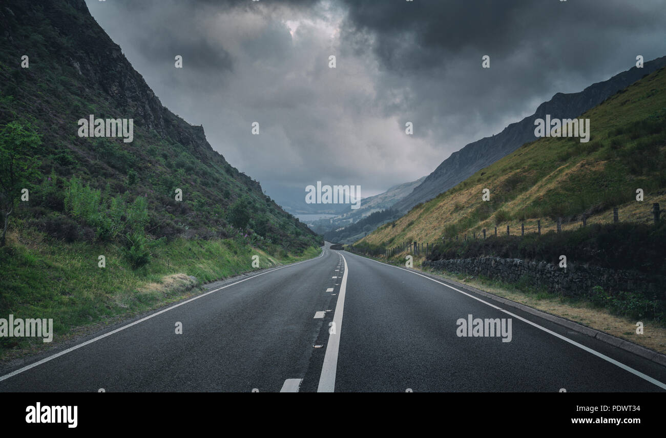 Empty asphalt road through Gwynedd mountain range at cloudy morning near Penygadair in Wales, UK Stock Photo