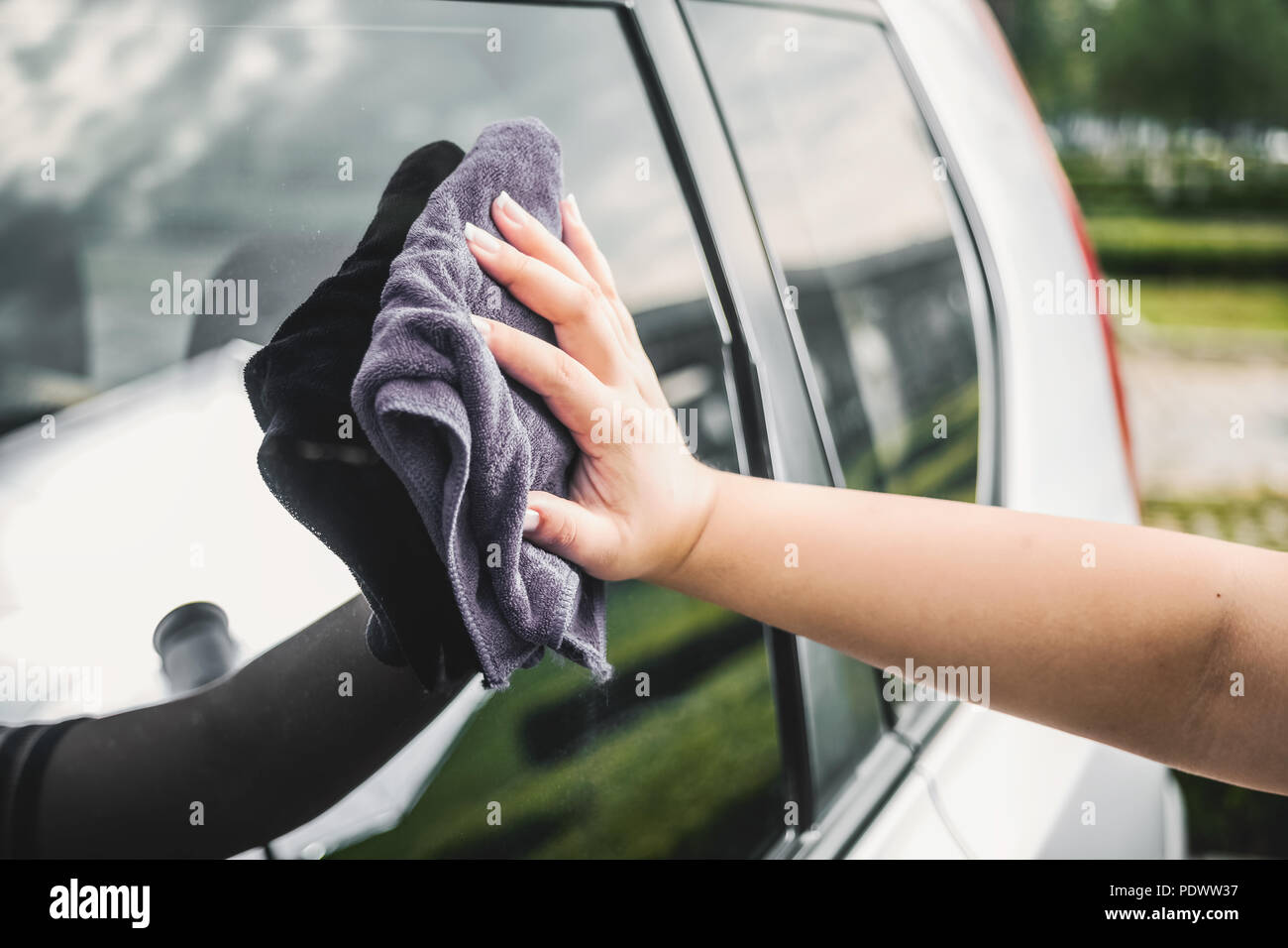 Closeup picture, image young woman, driver, dry wiping her car with