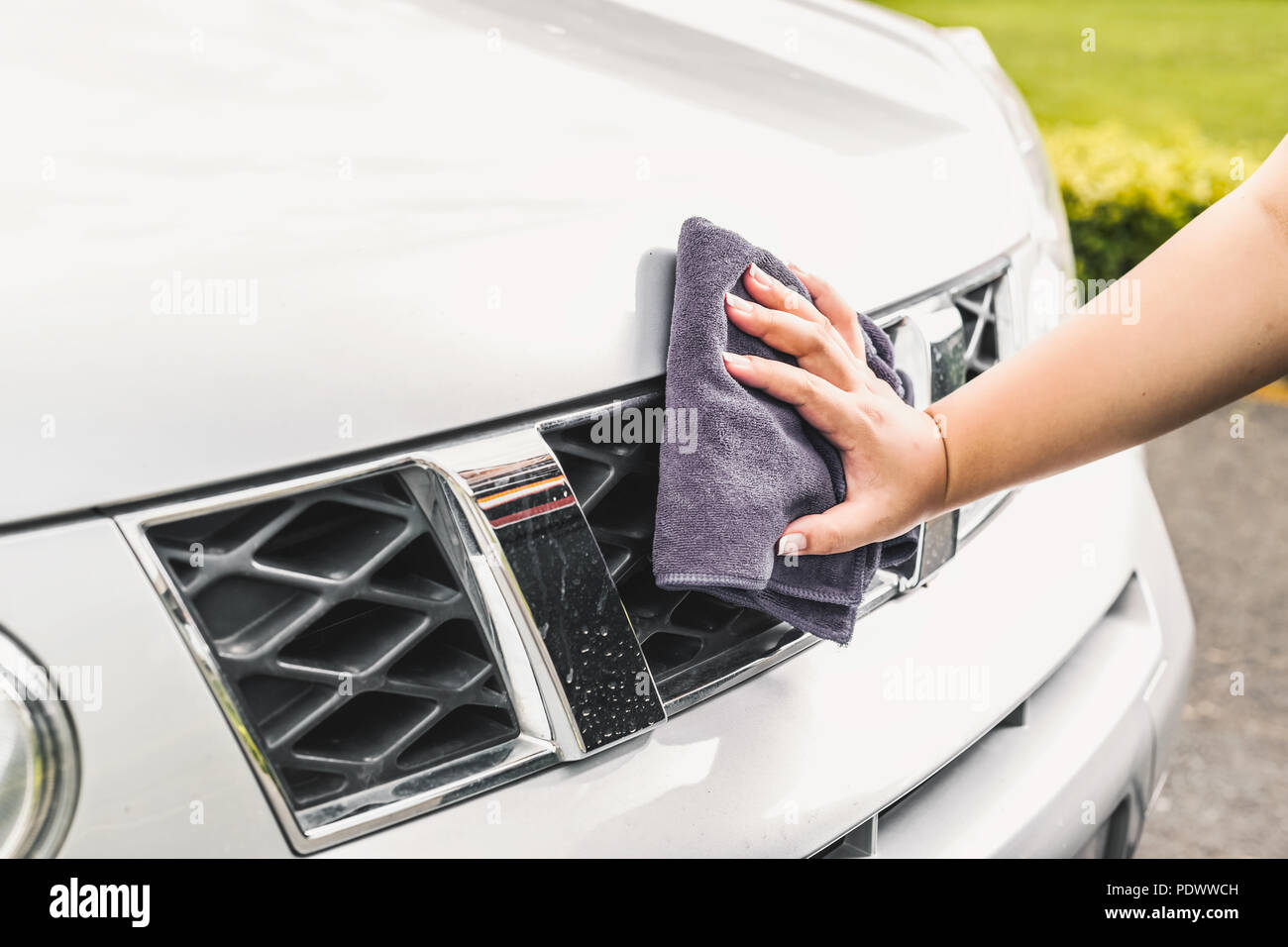 Closeup picture, image young woman, driver, dry wiping her car with