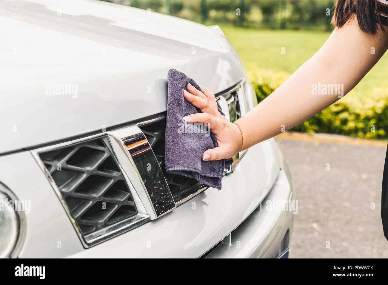 Closeup picture, image young woman, driver, dry wiping her car with