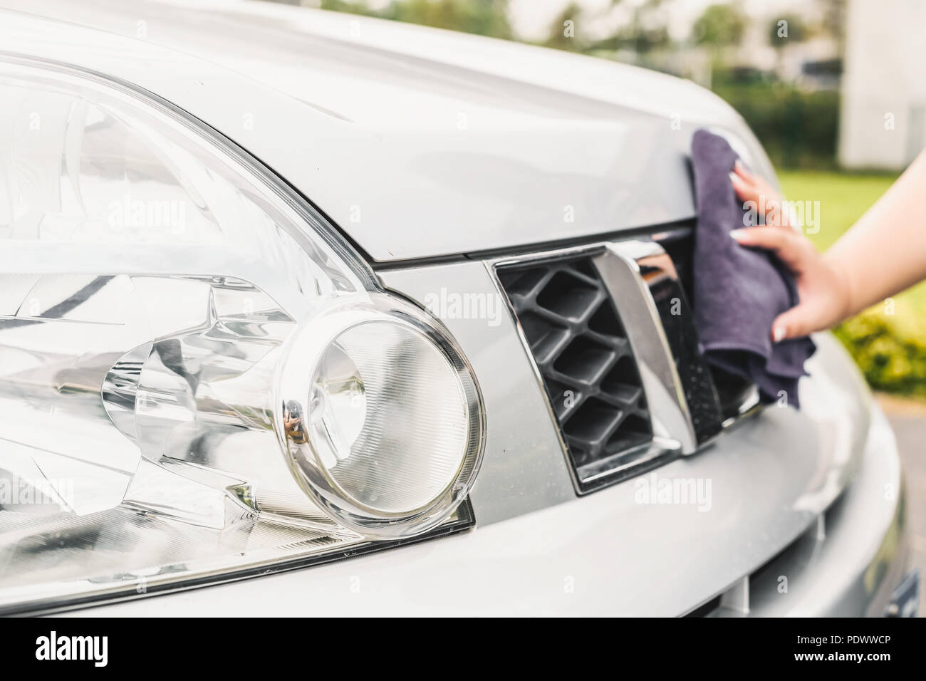 Closeup picture, image young woman, driver, dry wiping her car with