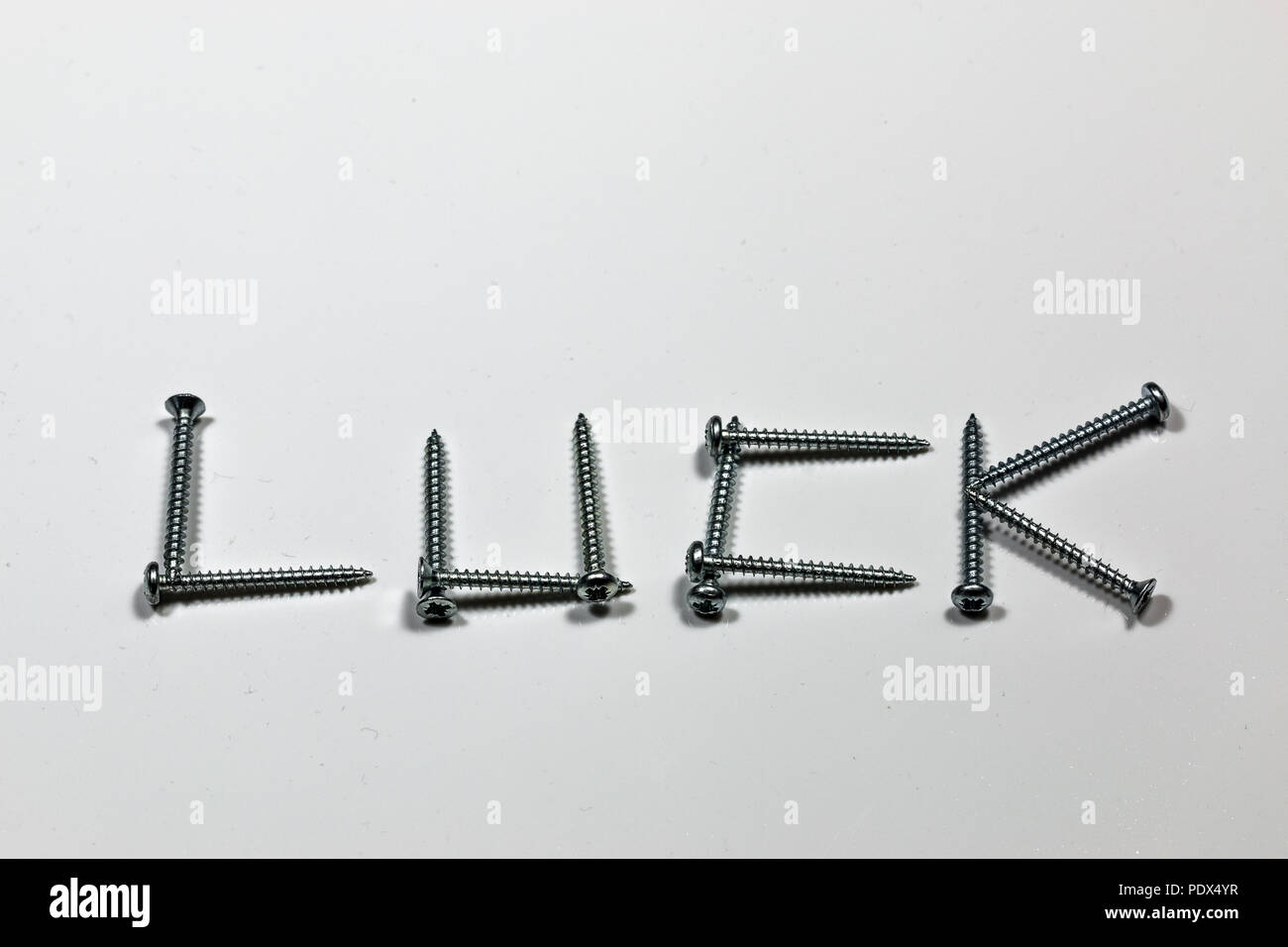 The word LUCK written with screws on white background Stock Photo