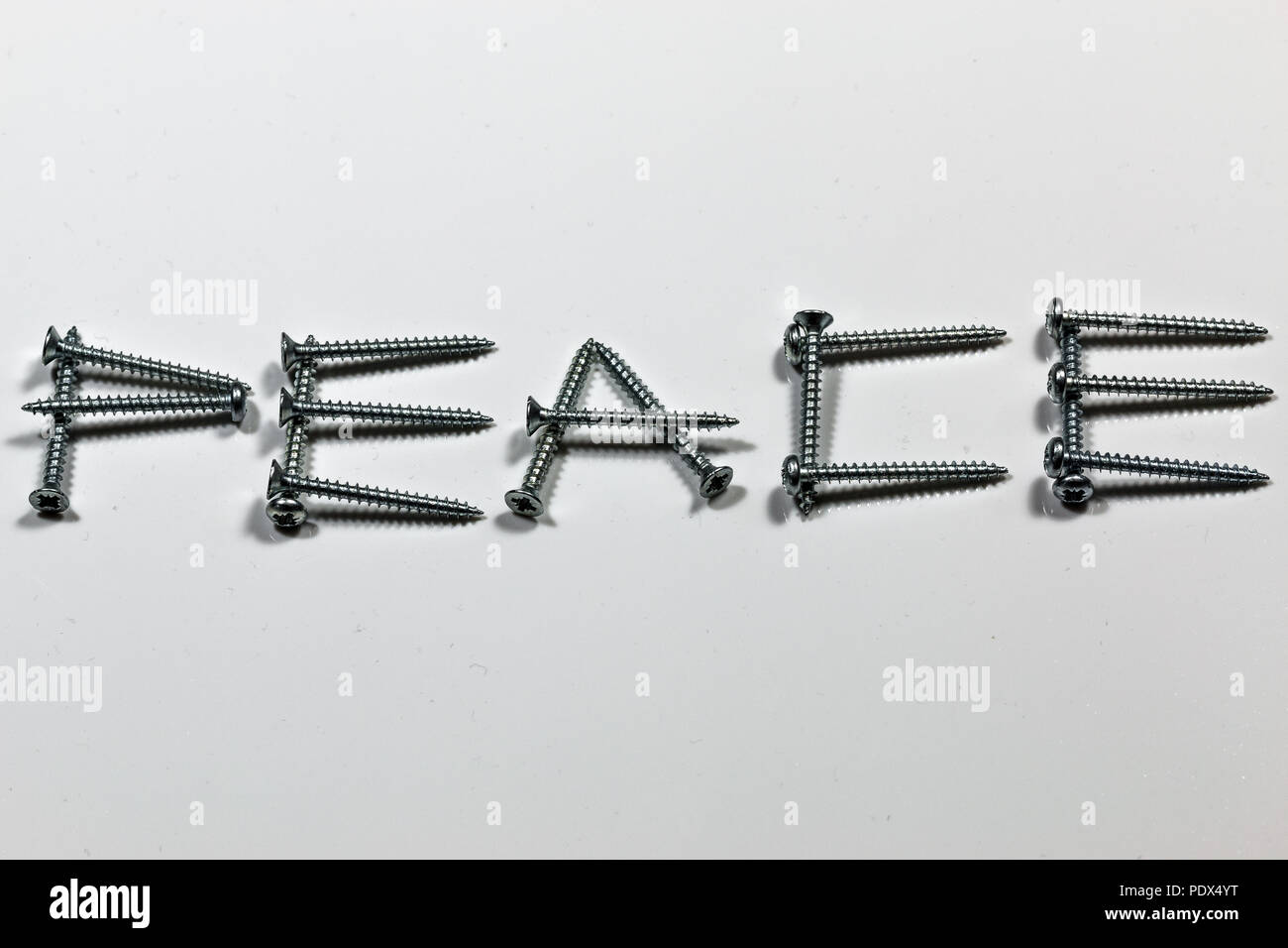 The word PEACE written with screws on white background Stock Photo