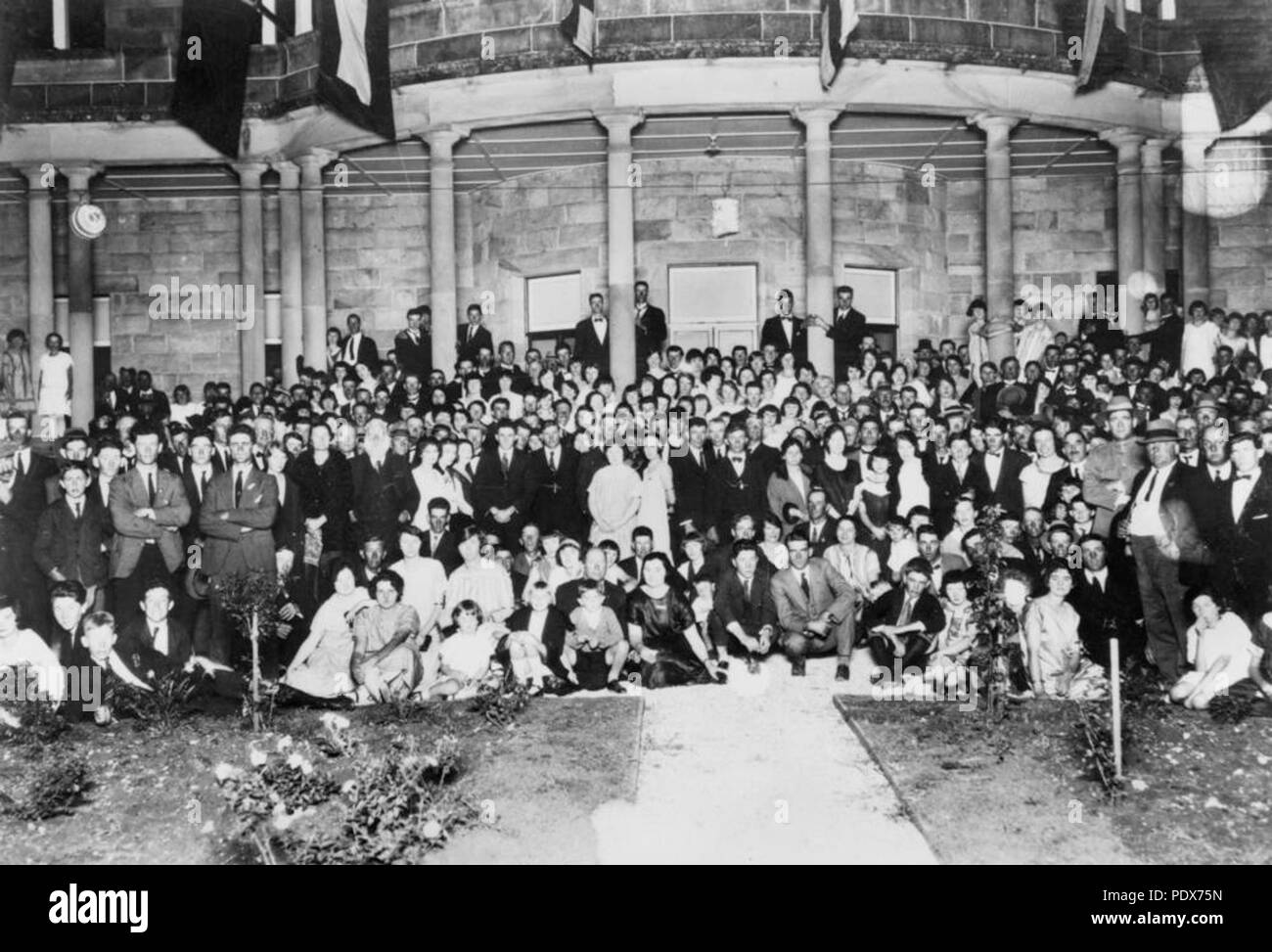 265 StateLibQld 1 40199 Guests at Jimbour House pose on the front steps under floodlights, 1925 Stock Photo