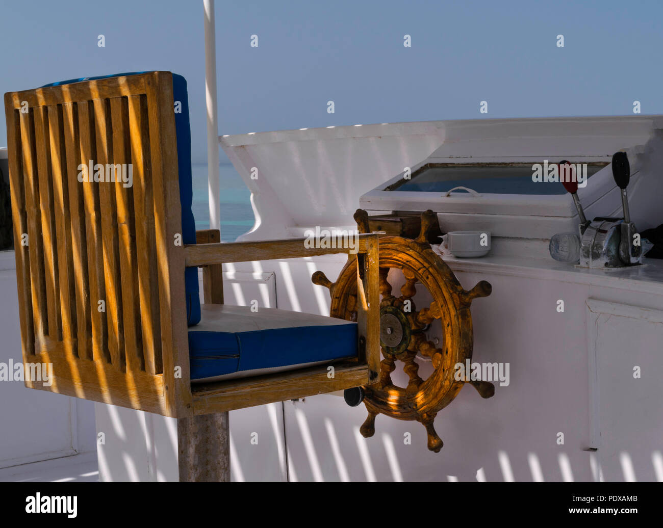 wooden old ship helm in red sea, travelling in white yacht Stock Photo