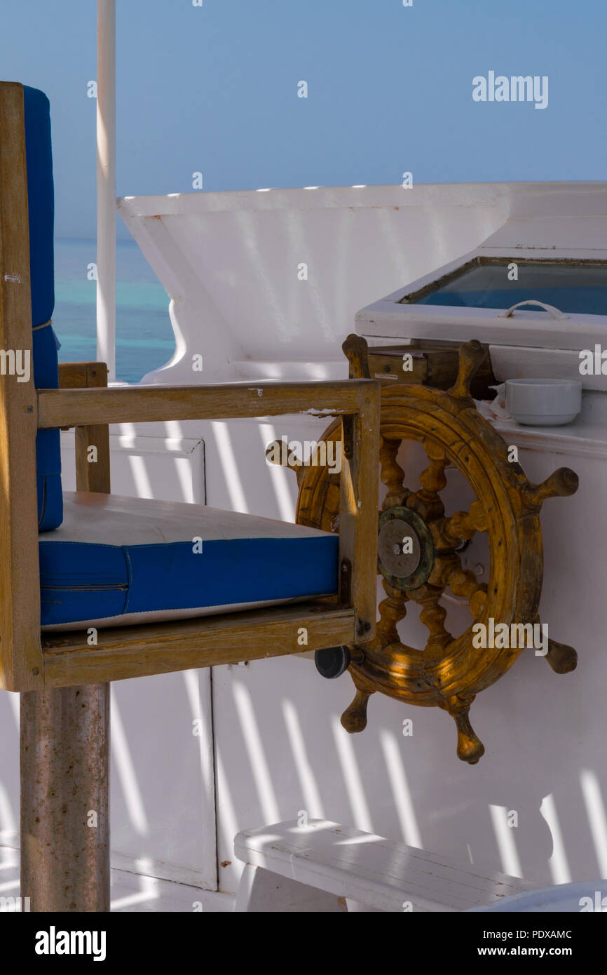 wooden old ship helm in red sea, travelling in white yacht Stock Photo