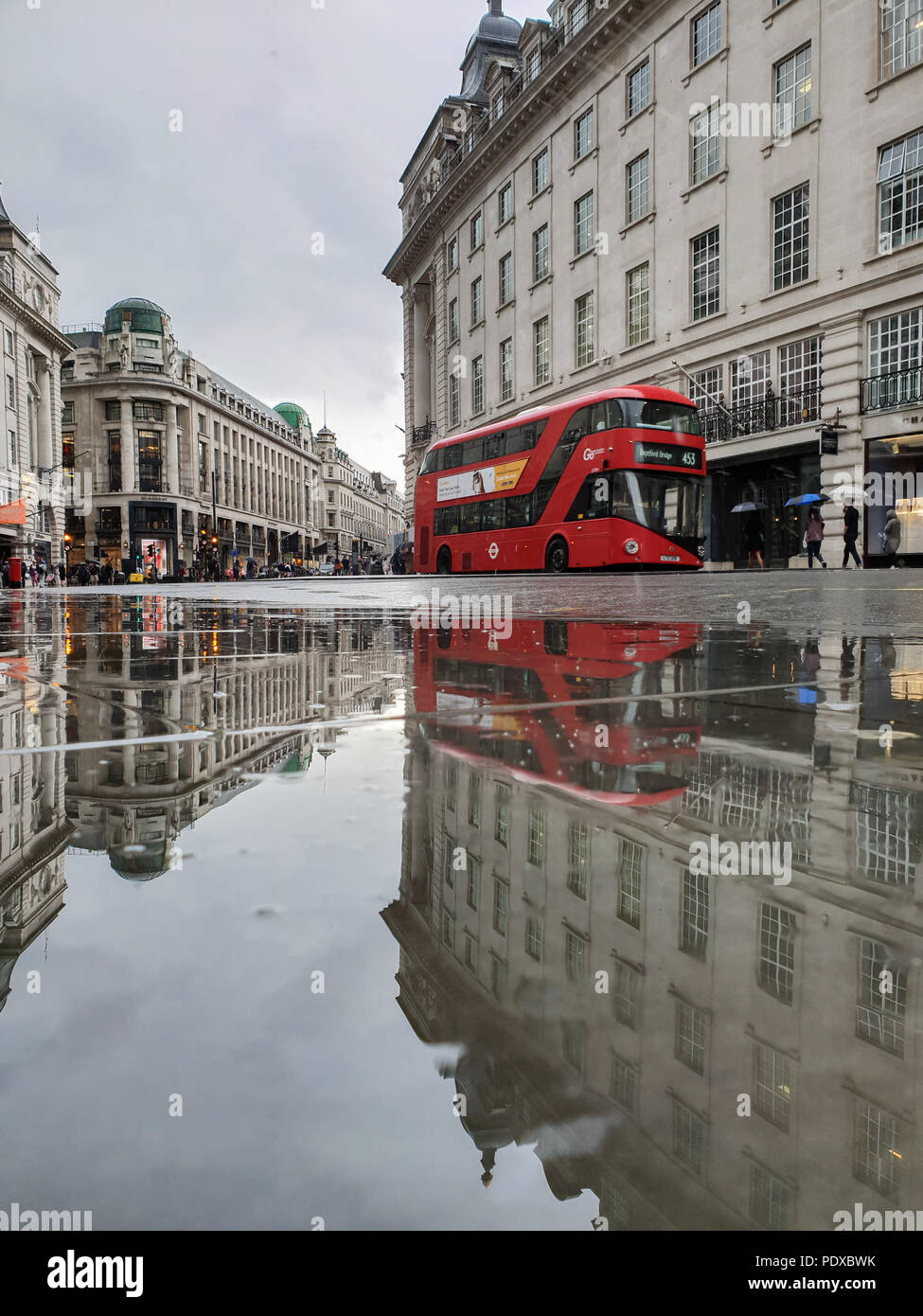 Regents Street. London. UK 10 Aug 2018 - A reflection of London red double decker bus in a large puddle of rain water in Regent Street after a heavy rainfalls in central London.  Credit Roamwithrakhee /Alamy Live News Stock Photo