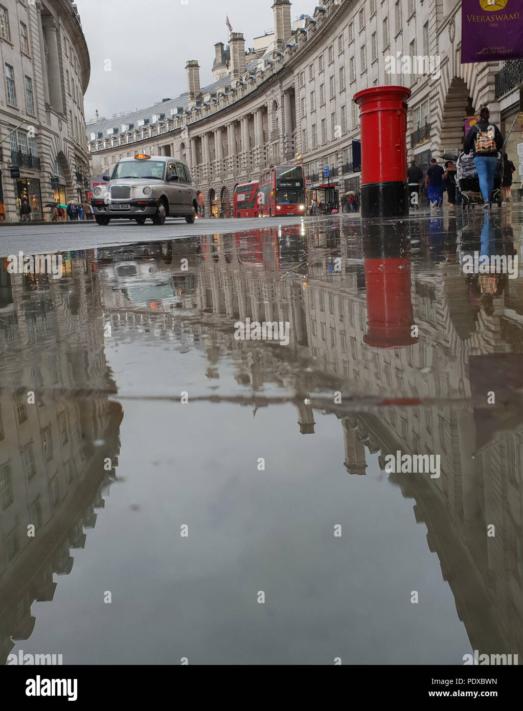 Regents Street. London. UK 10 Aug 2018 - A reflection of London black taxi and a postbox in a large puddle of rain water in Regent Street after a heavy rainfalls in central London.  Credit Roamwithrakhee /Alamy Live News Stock Photo