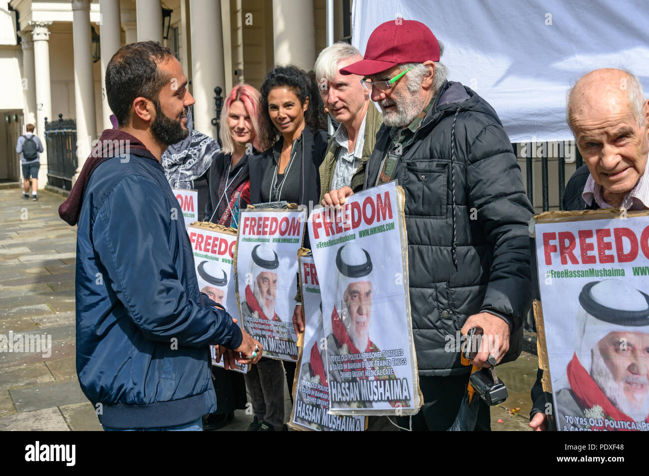 London, UK. 10th August 2018. Ali Mushaima (left) who has been on hunger strike at the Bahrain embassy since the start of August to save his fathers life speaks with campaigners at the vigil by Inminds Islamic human rights organisation vigil calling for the immediate release of Hassan Mushaima and all the other 5000 Bahraini prisoners of conscience languishing in the Al-Khalifa regimes jails. They also demanded the British government end its complicity in the Al Khalifa dictatorship's crimes against the Bahraini people. Credit: Peter Marshall/Alamy Live News Stock Photo