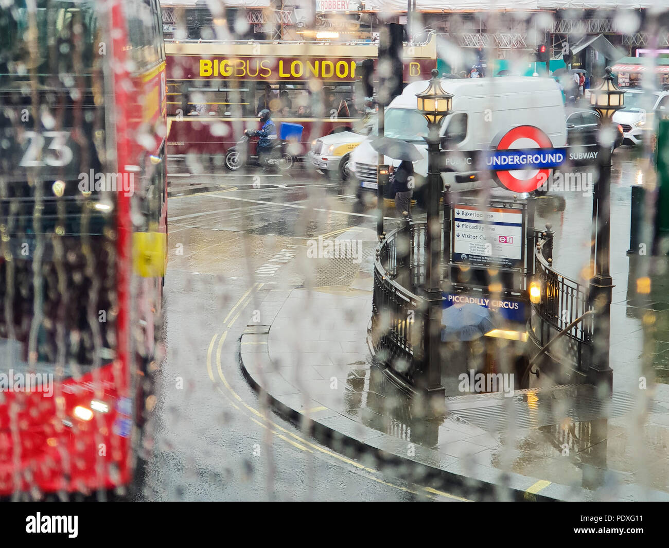 Westminster. London. UK 10 Aug 2018 - View of Piccadilly Circus tube station through a double decker bus window covered with raindrops.  Credit Roamwithrakhee /17�Թ����� Live News Stock Photo