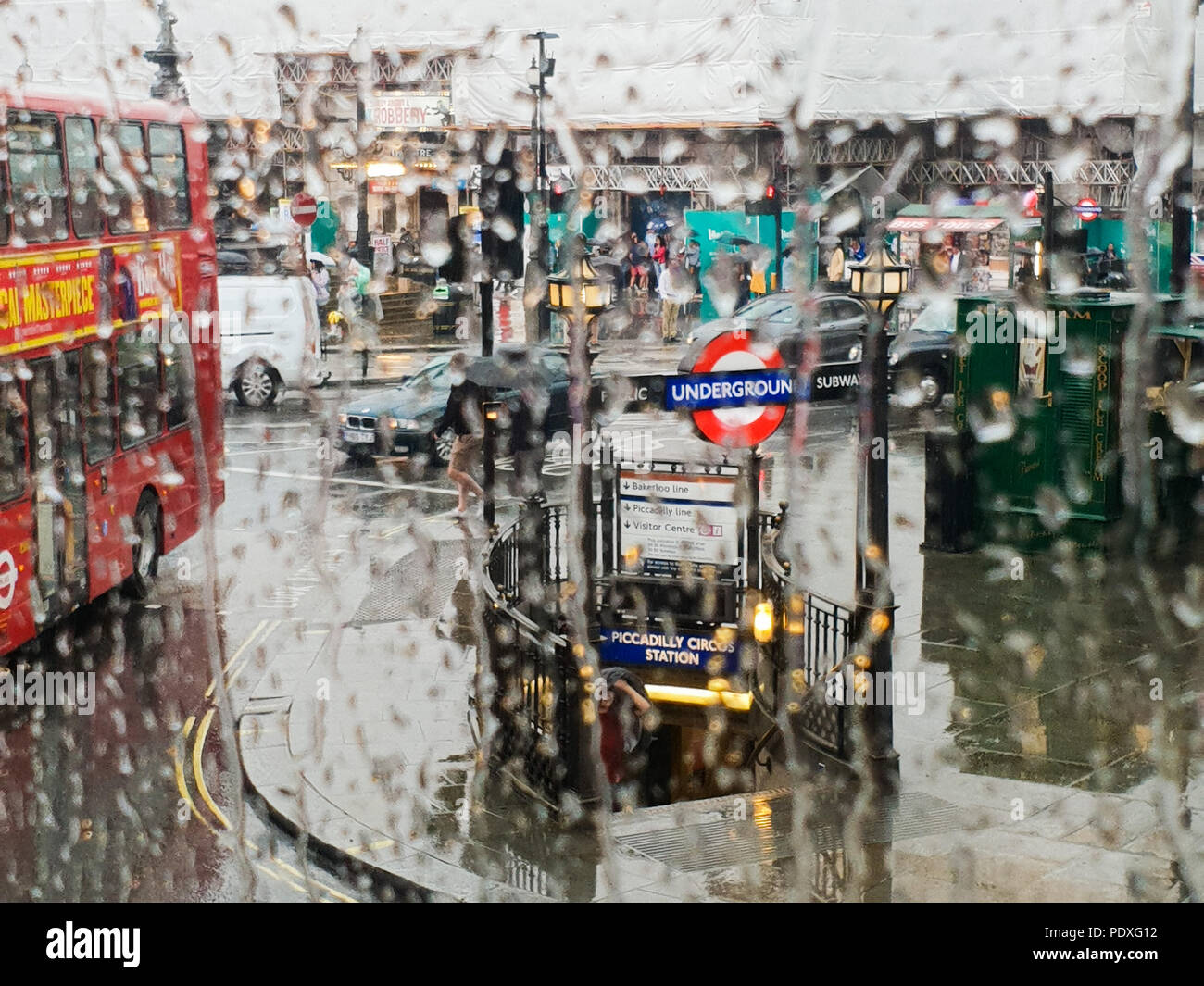 Westminster. London. UK 10 Aug 2018 - View of Piccadilly Circus tube station through a double decker bus window covered with raindrops.  Credit Roamwithrakhee /17�Թ����� Live News Stock Photo