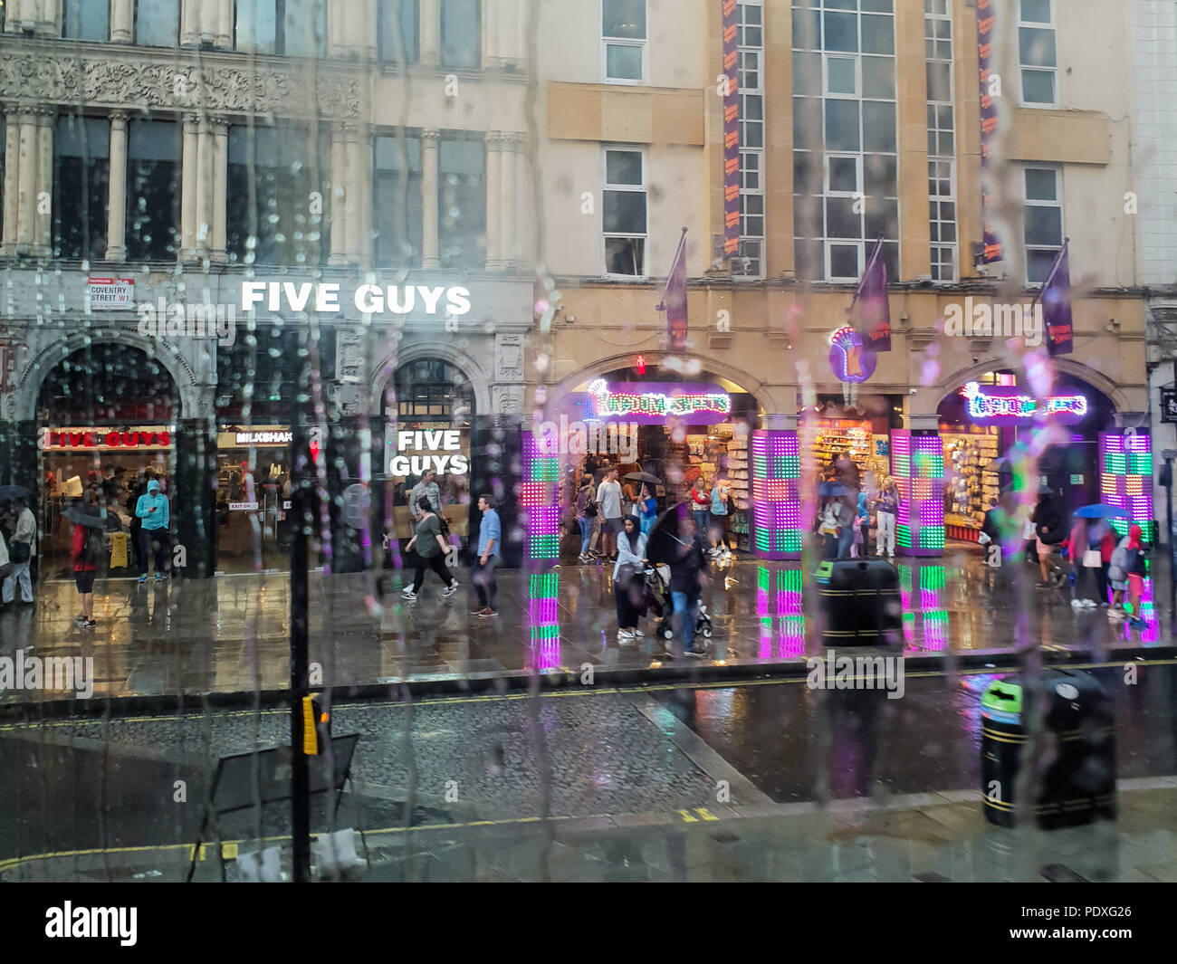 Westminster. London. UK 10 Aug 2018 - View of shops in Piccadilly Circus through a double decker bus window covered with raindrops.  Credit Roamwithrakhee /17�Թ����� Live News Stock Photo