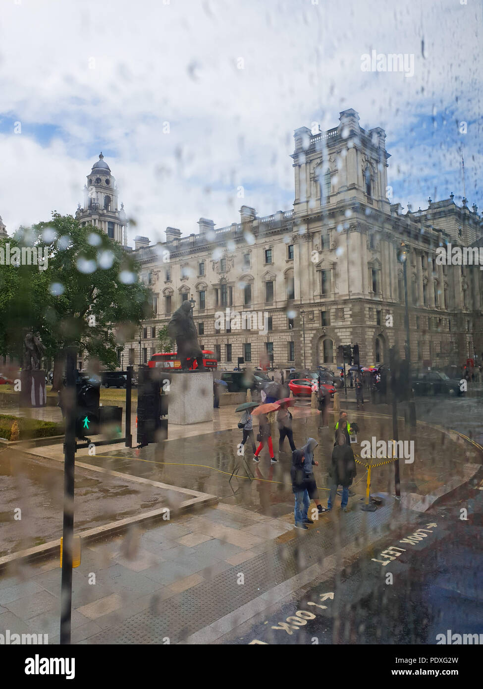 Westminster. London. UK 10 Aug 2018 - View of Parliament Square through a double decker bus window covered with raindrops.  Credit Roamwithrakhee /17�Թ����� Live News Stock Photo