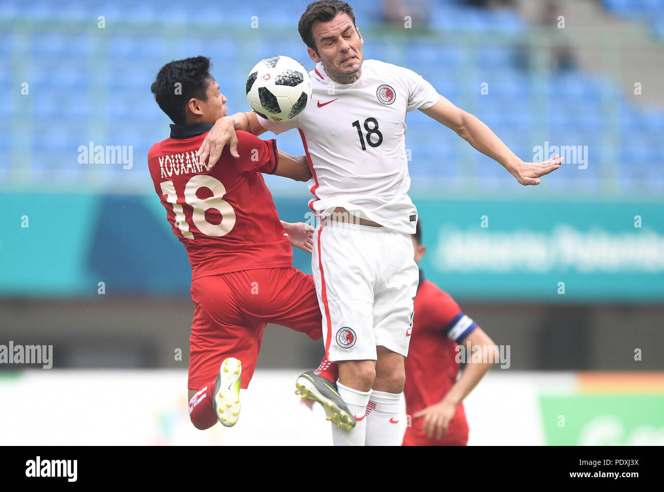 Bekasi, Indonesia. 10th Aug, 2018. Jorge Tarres Paramo (R) of Hong Kong of China vies with Sihalath Xouxana of Laos during the Men's Football Group A match at the 18th Asian Games at Patriot Stadium in Bekasi, Indonesia, Aug. 10, 2018. Credit: Jia Yuchen/Xinhua/Alamy Live News Stock Photo